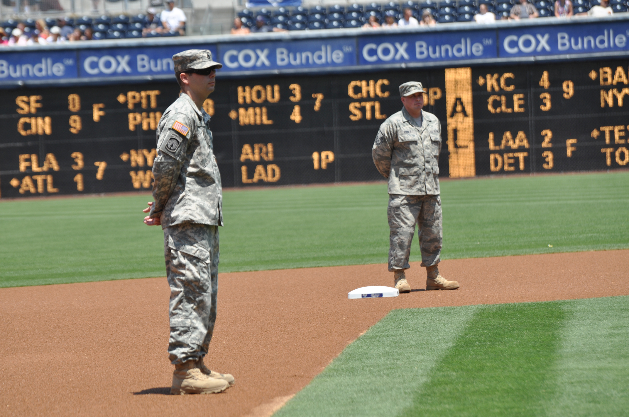 three men in uniforms standing at a base ball diamond