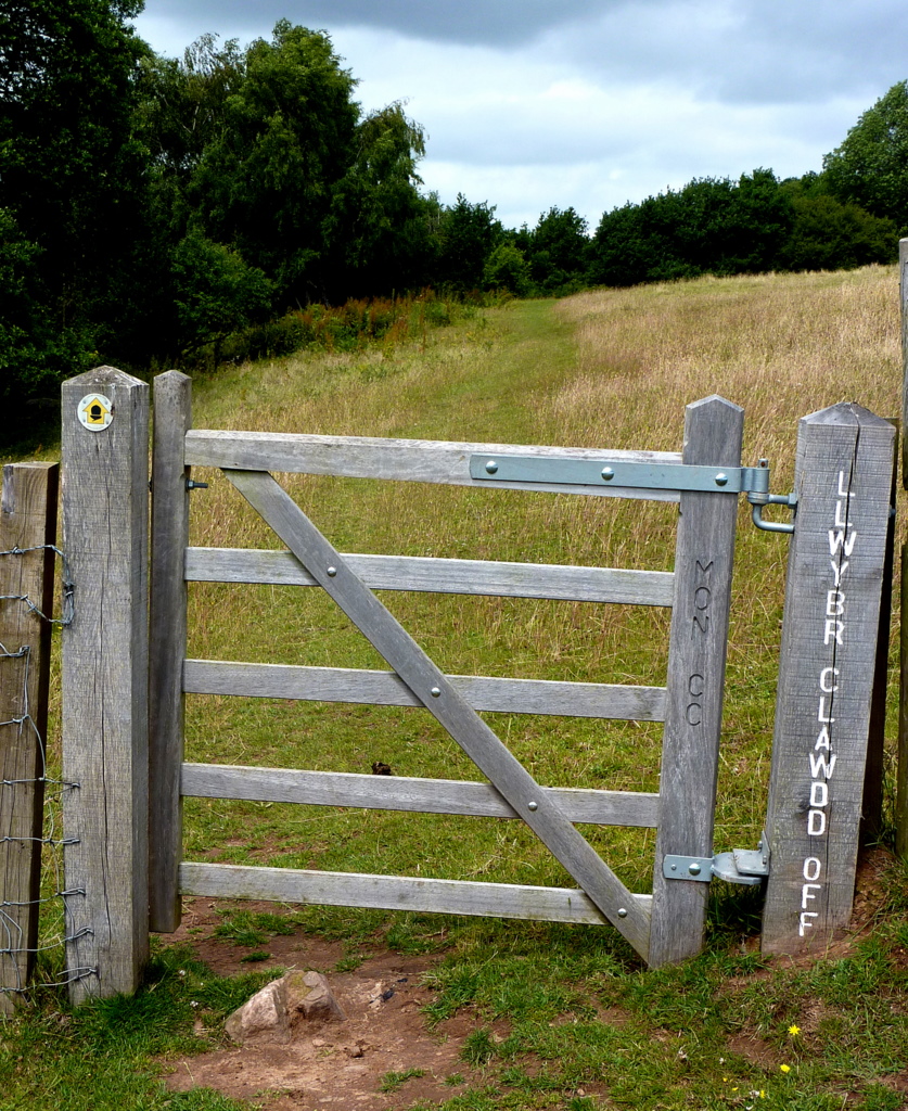 an old wooden gate with signs on it