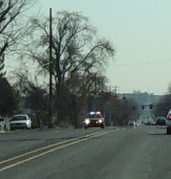 two police cars stopped on the side of the road
