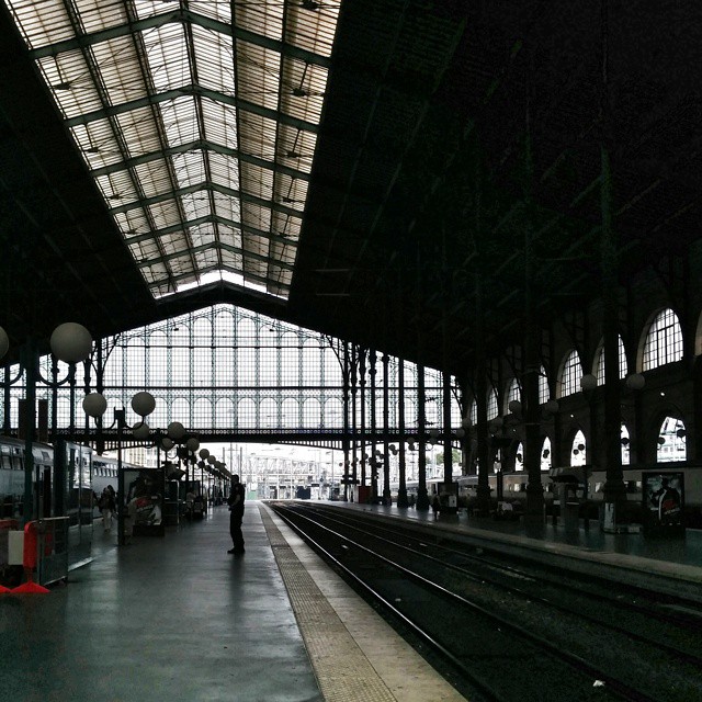 a lone person stands alone inside an empty station