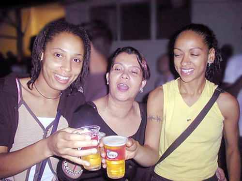 three young ladies holding cups at a gathering
