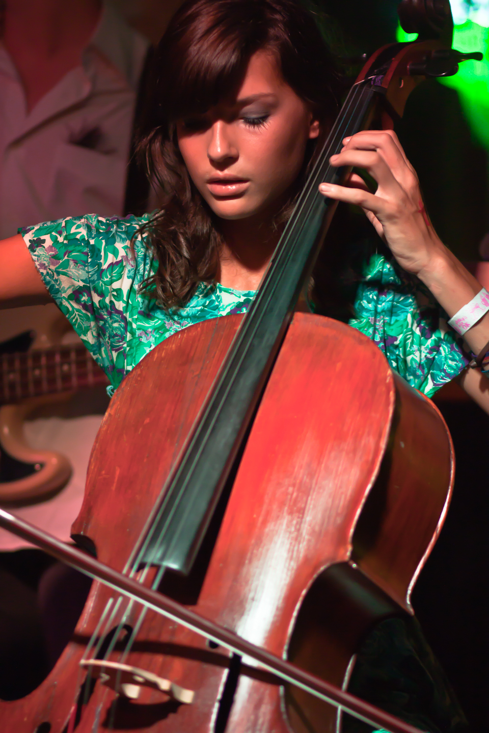 a girl is playing a cello while on stage