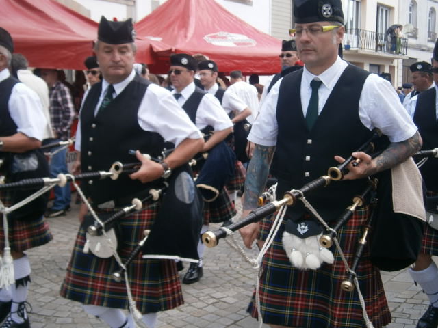 men wearing uniforms in street parade and pipes