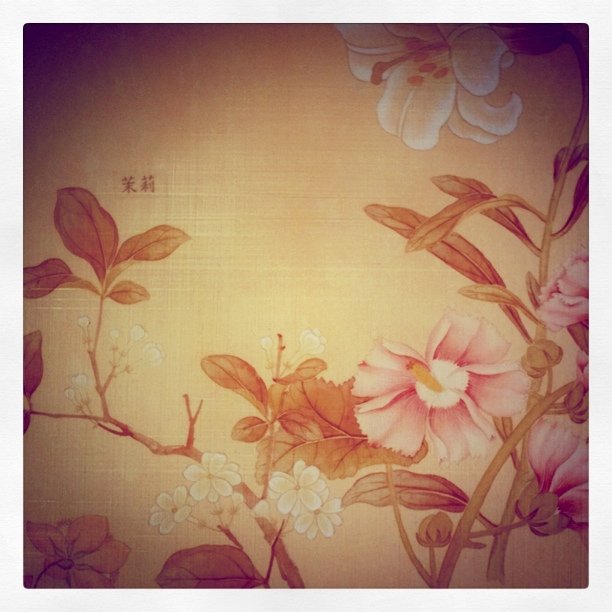 an artistic picture with pink flowers in a yellow room