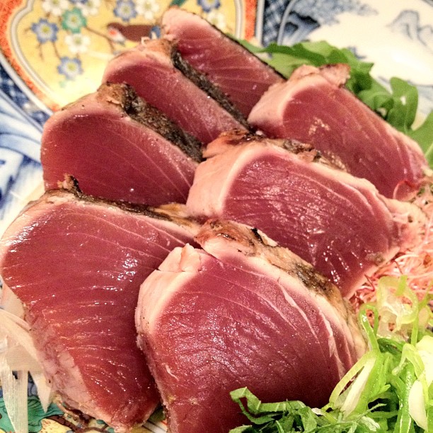 sliced tuna on plate with salad and bread