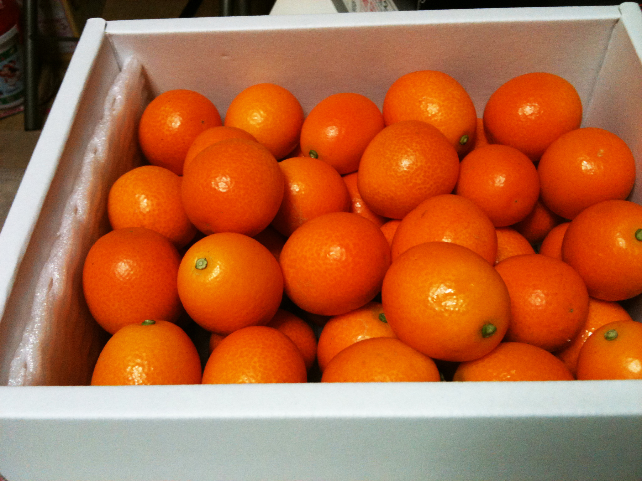 a cardboard container filled with lots of oranges