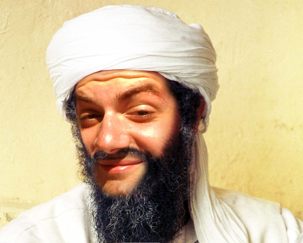 a man with a beard, wearing white, wearing a head scarf