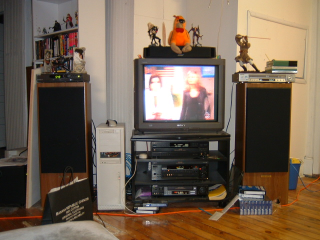 an entertainment center with a television in the middle and other electronic equipment on top of it