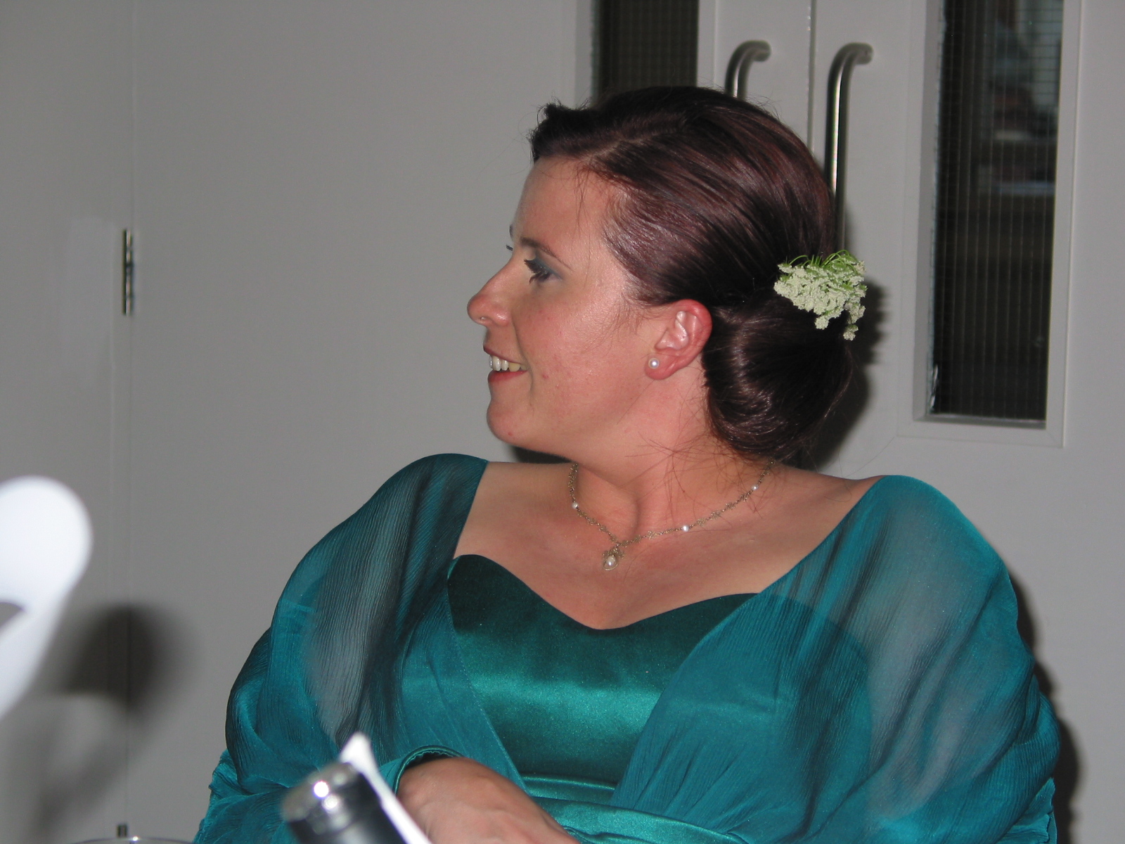 woman in teal dress with a flower in her hair