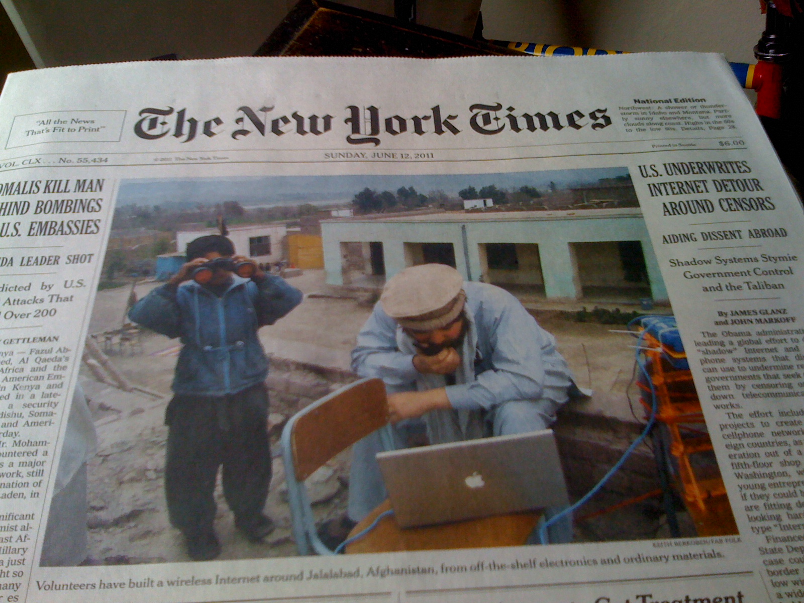 newspapers article about two workers using their laptops