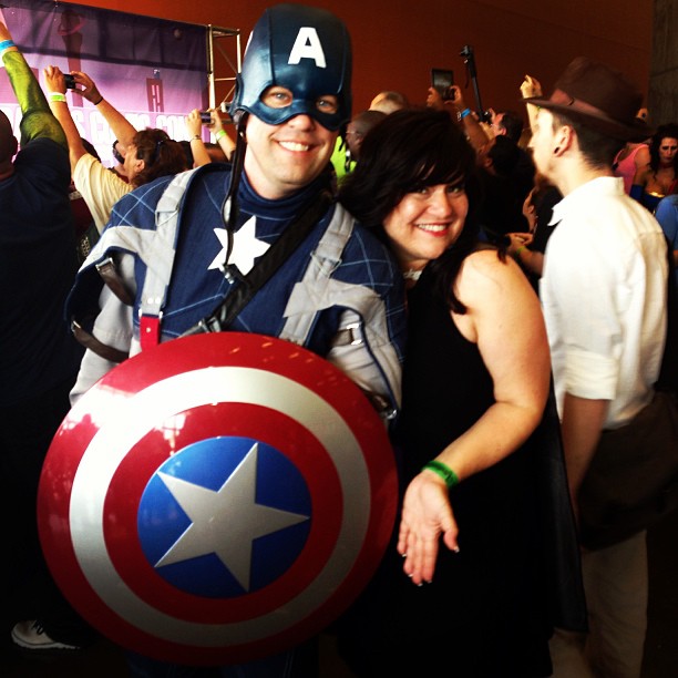 two people posing for a po while one woman holds up a helmet