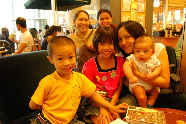 people sitting on a booth holding baby and baby