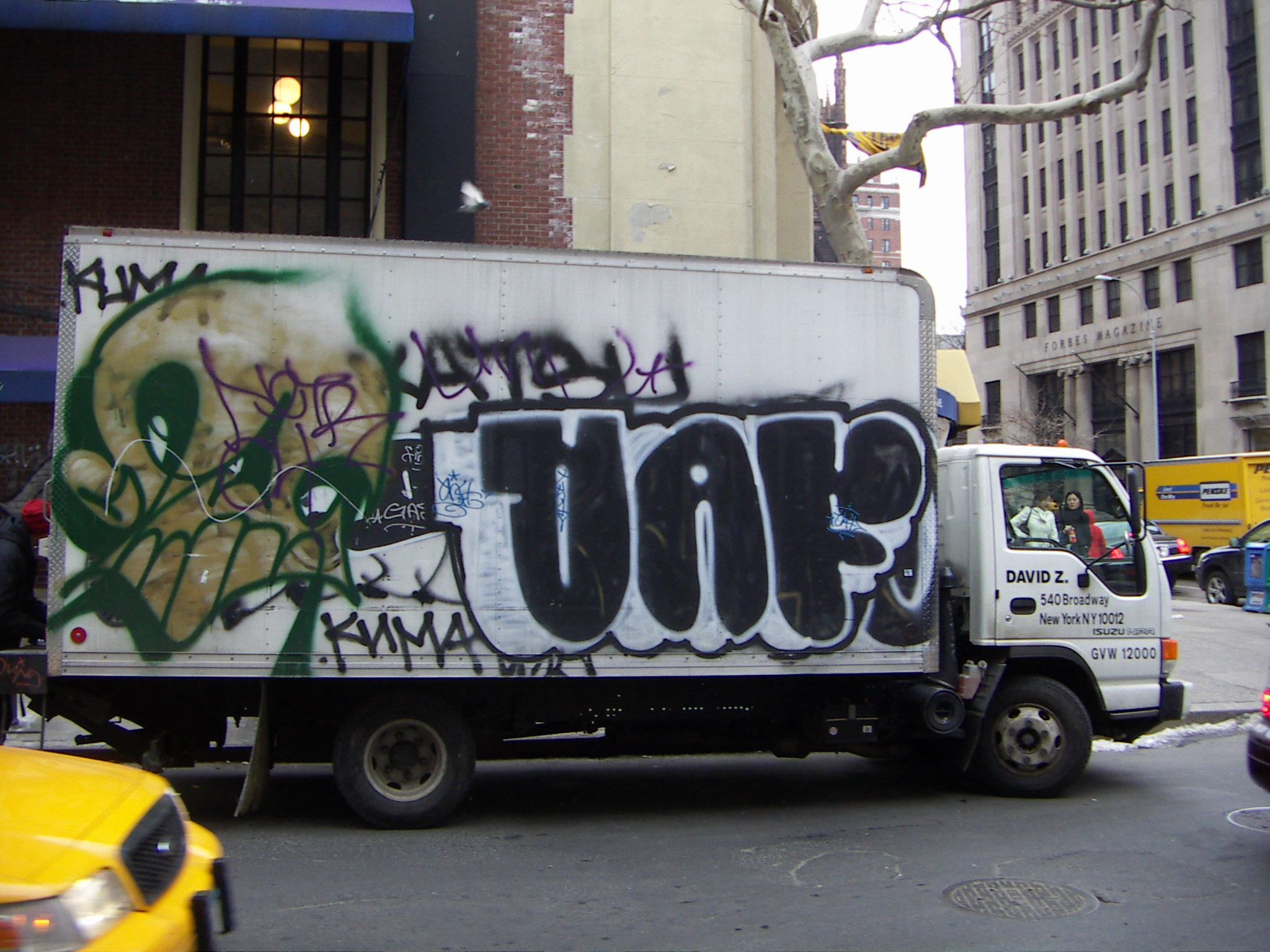 the truck is driving down the street with grafitti on it
