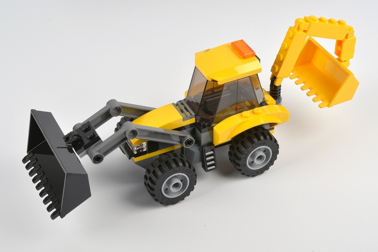 toy construction vehicle with large digging attachment on white surface