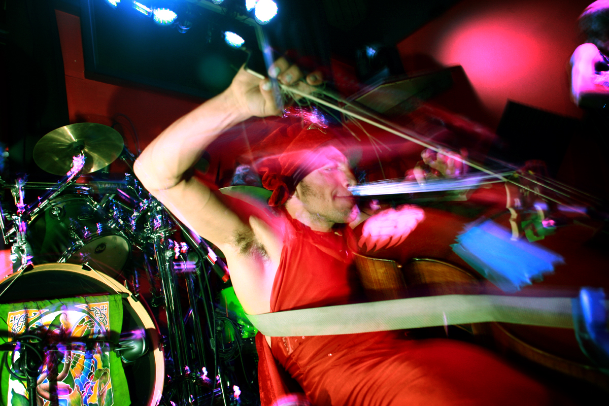 a man standing and playing the guitar on stage