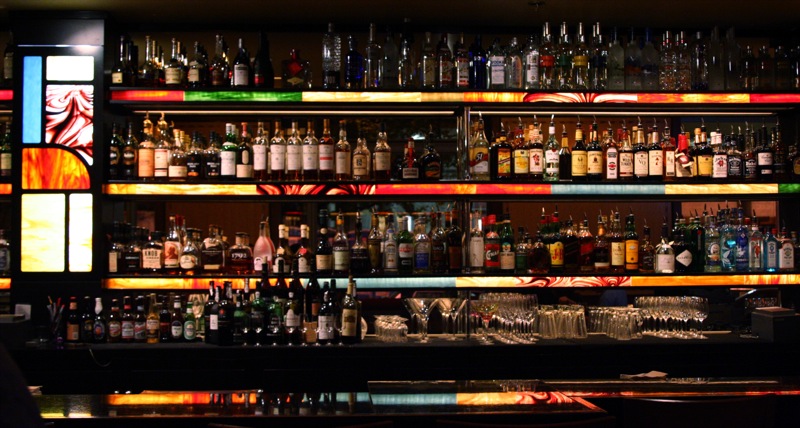 an arrangement of liquor bottles line a bar