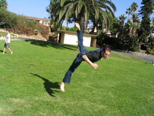 a man does a hand stand in the grass