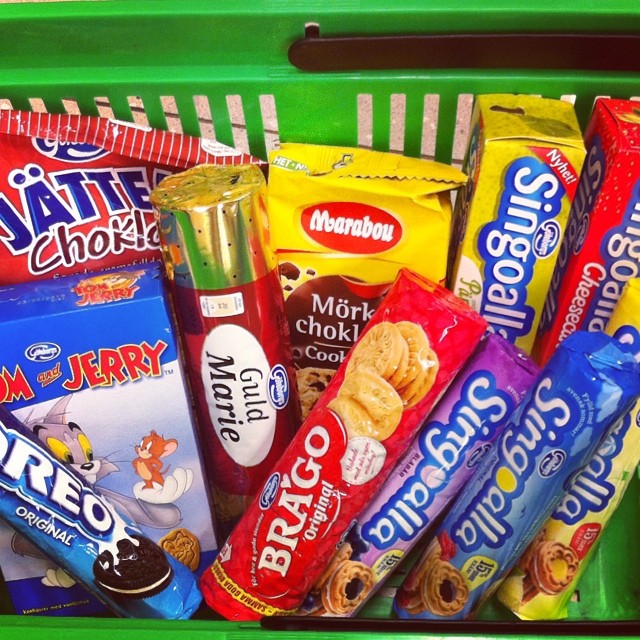 a green basket that has a variety of snacks in it