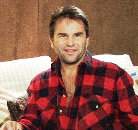 a man in red and black pajamas is holding a remote