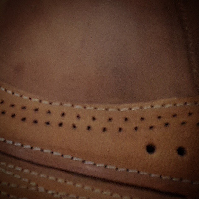 the bottom of a man's tan shoes with holes