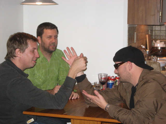 three people are at the table and one is holding his hands out for him