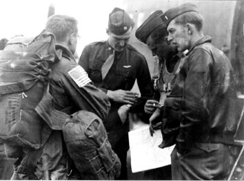 men in military uniforms standing around and looking at soing on a clip board