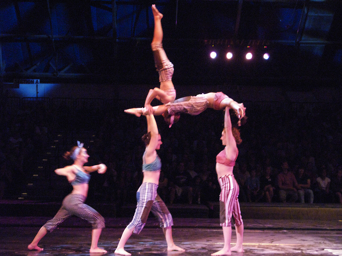 three people doing acrobatic poses on stage
