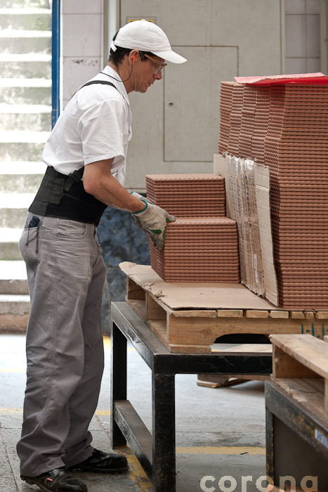man in white shirt and grey pants working with stacks of bricks