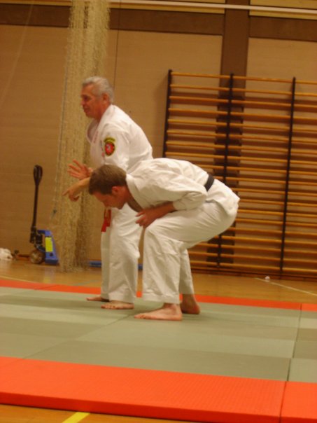 a man doing some karate tricks with another man standing over