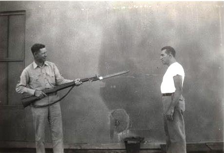 two men who are standing outside with a hose