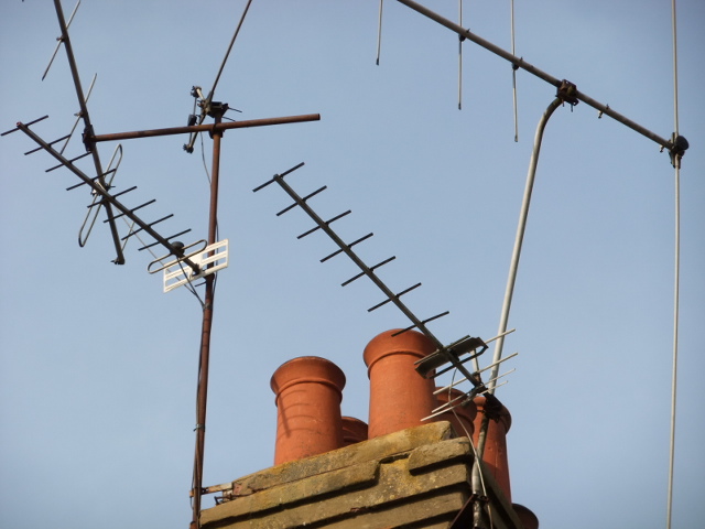 two rooftop toppers with wires on them and antennas above them