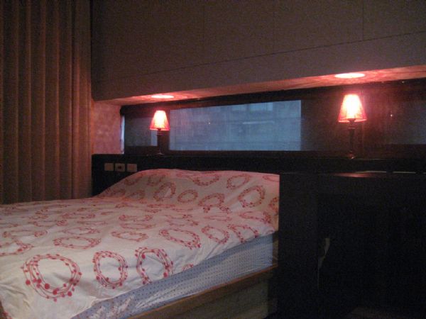 the large bed is set with two nightstand lamps