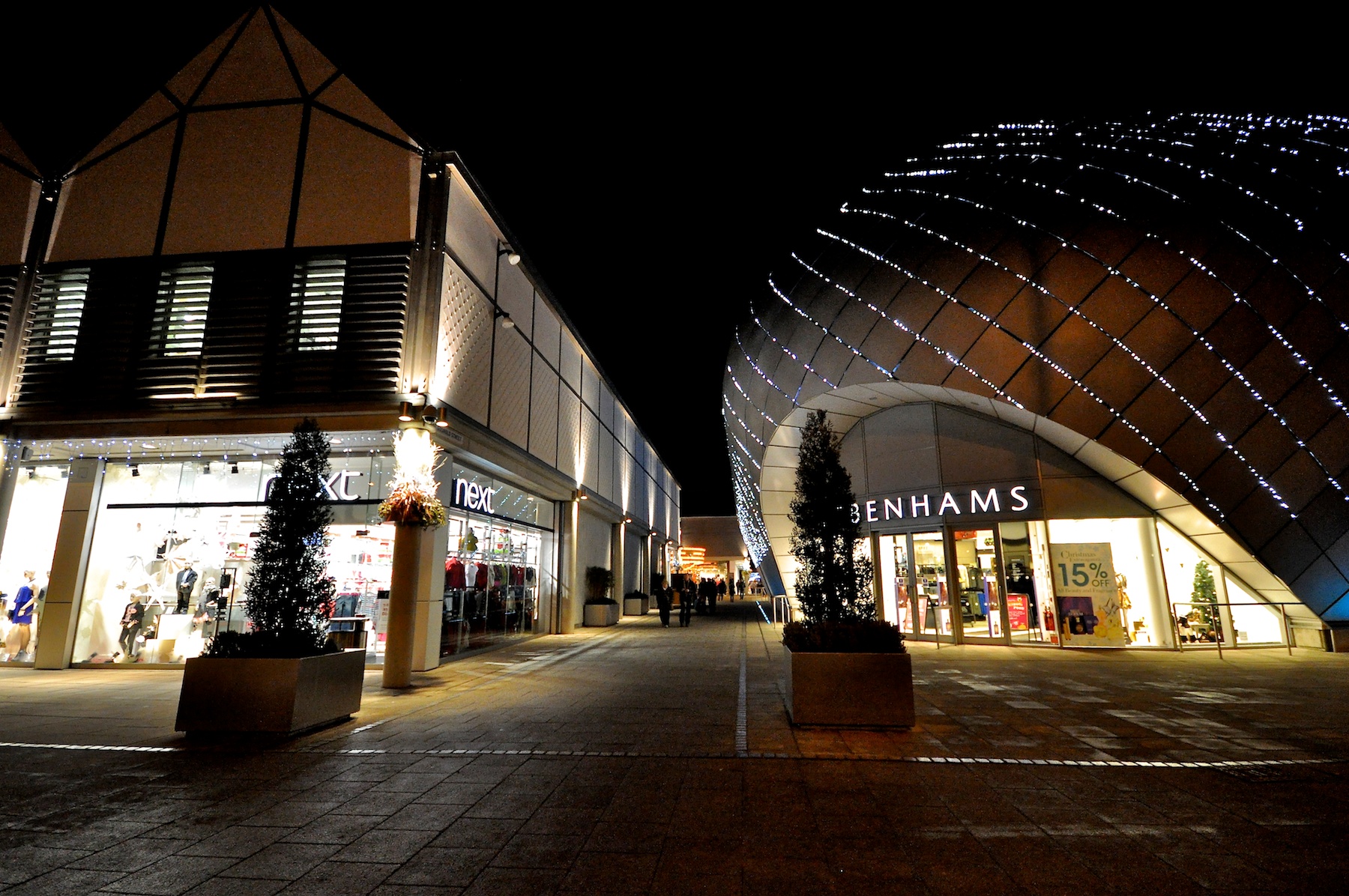 buildings in an area with lights on the sides and trees all around