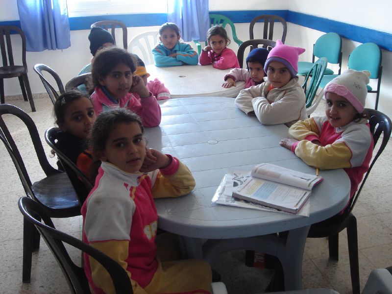 several children sitting around a table looking up