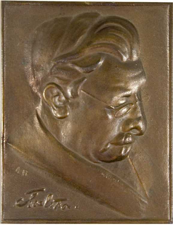 a bronze plaque depicts a portrait of an old man