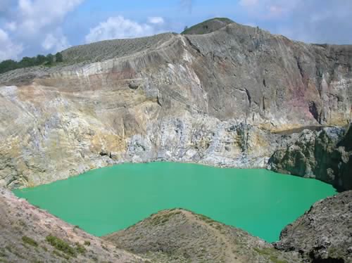 a large crater is surrounded by green water