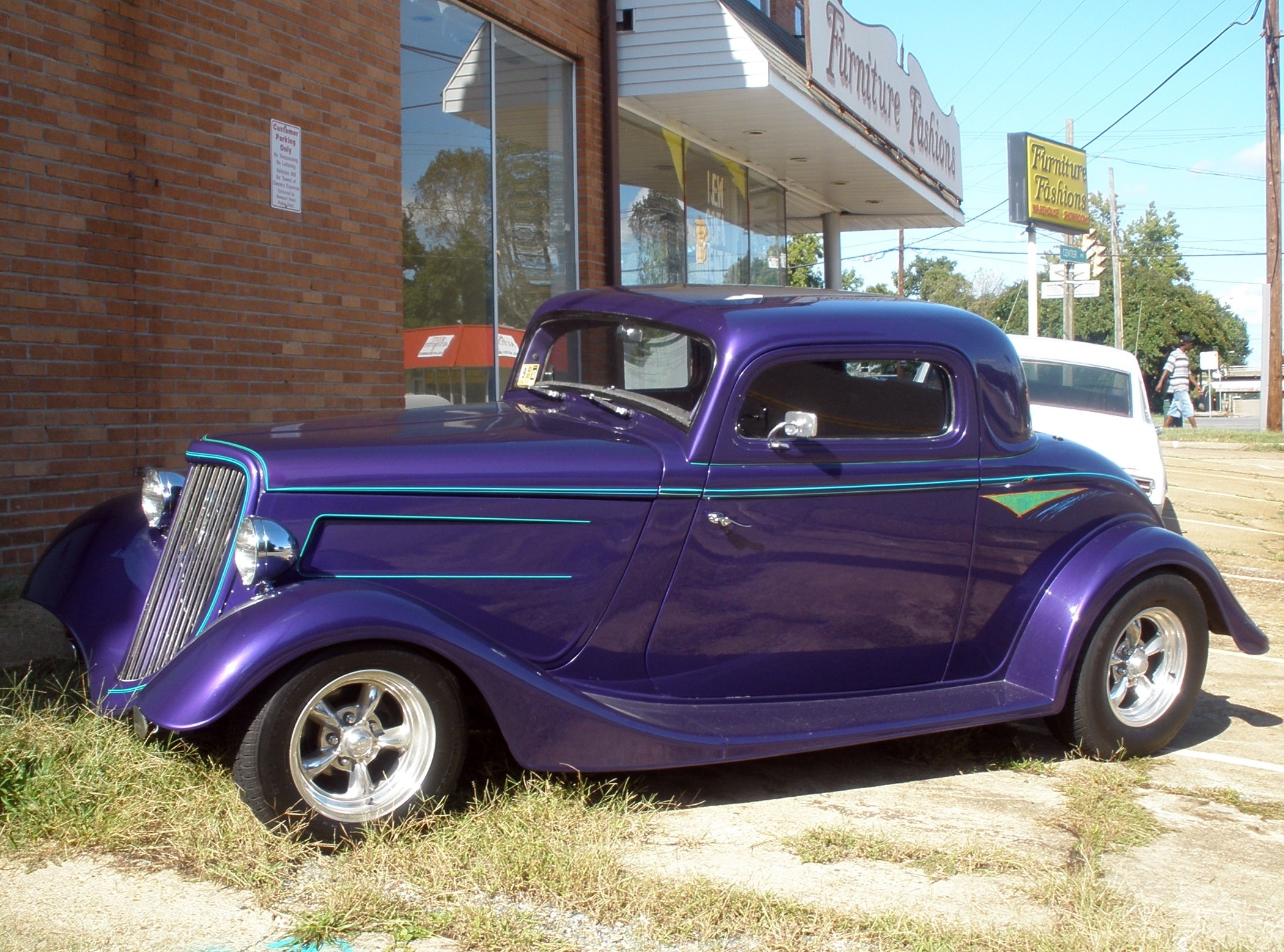 an antique car parked in front of a building