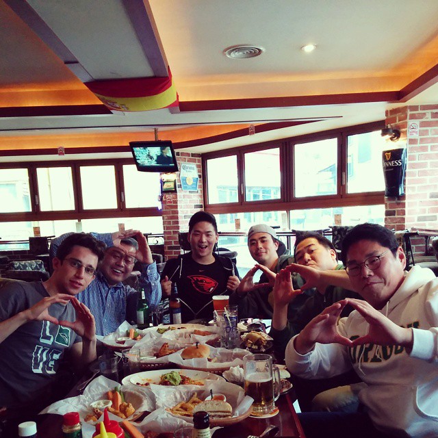 group of people sitting around a table eating food