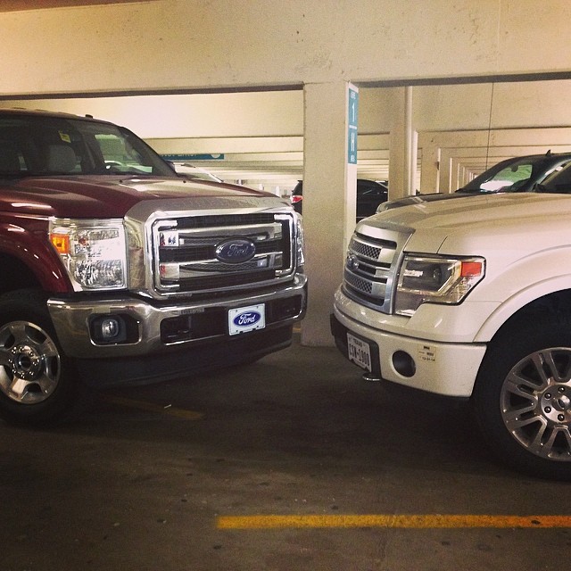 two trucks sitting side by side in a parking garage
