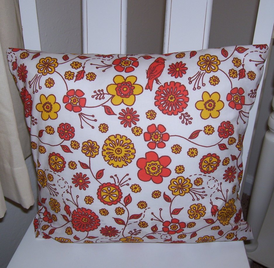 a white pillow with orange and red flowers