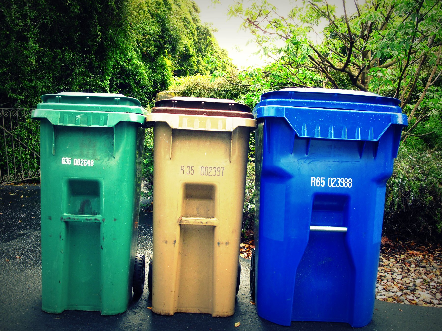 a series of three trash bins sitting side by side
