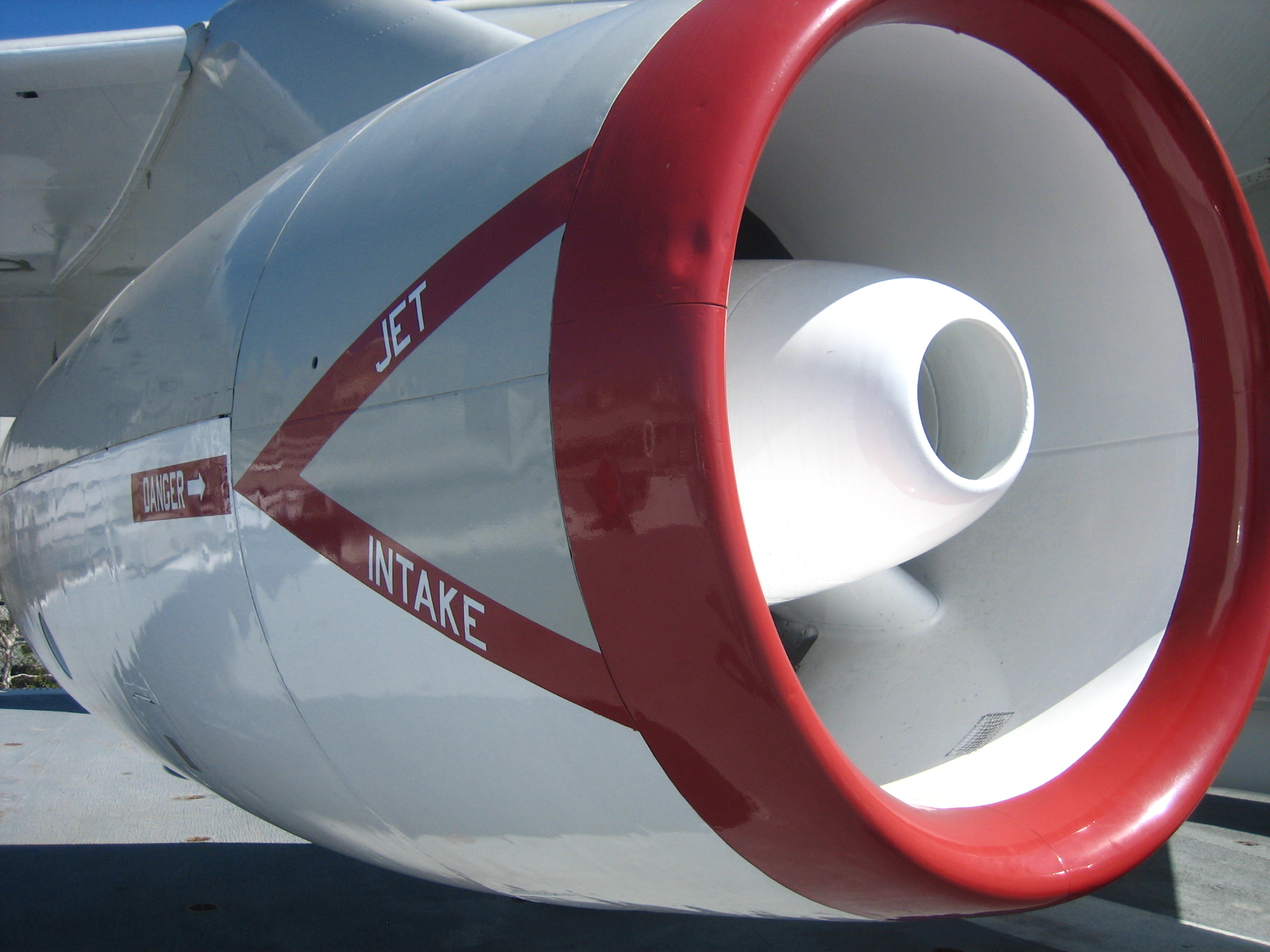 an airplane with a jet engine and a red and white stripe