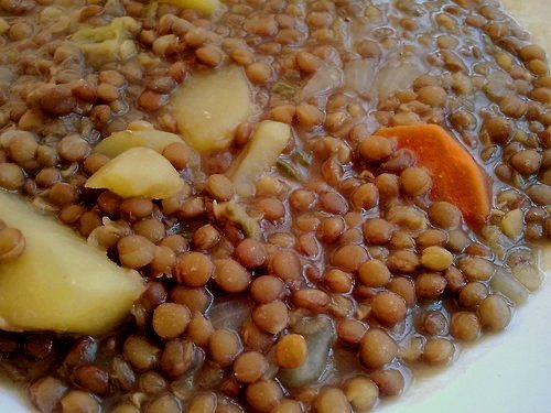 a white bowl filled with lots of beans and apples
