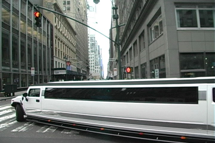 a limousine on a city street in front of skyscrs