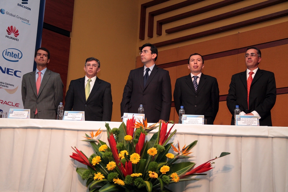 several men in business suits are standing behind a table