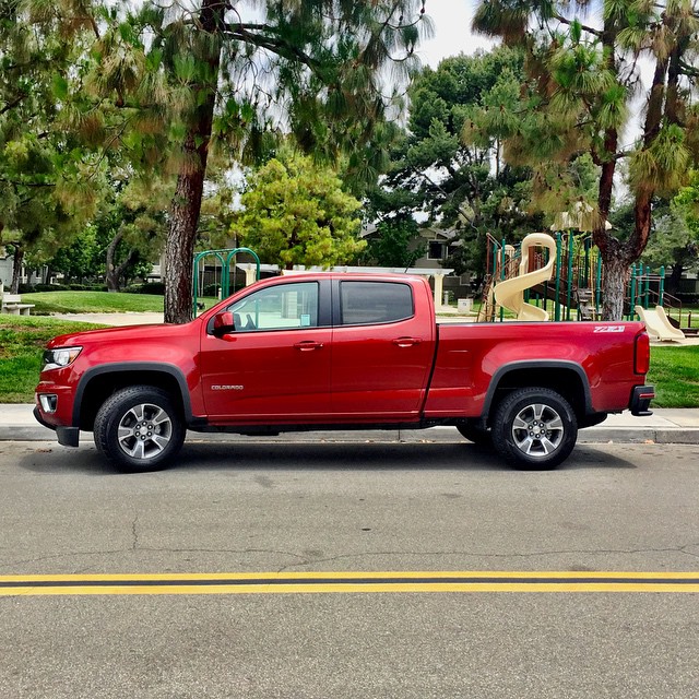 a red truck is parked in front of a park