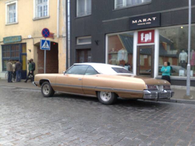a car parked in front of a store on the street
