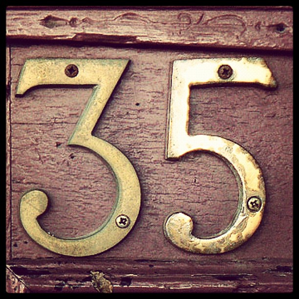 a close up of a metal number mounted to a wall