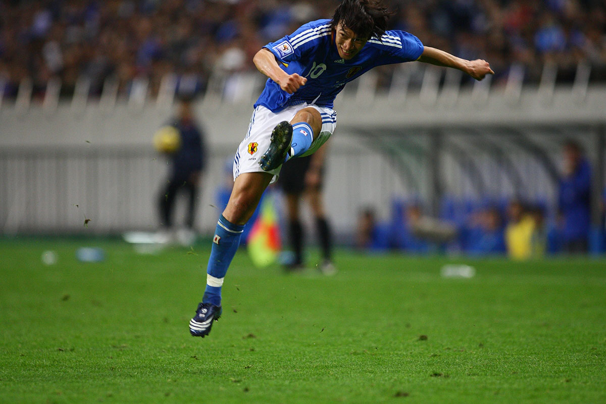 a soccer player runs as the ball is coming towards him