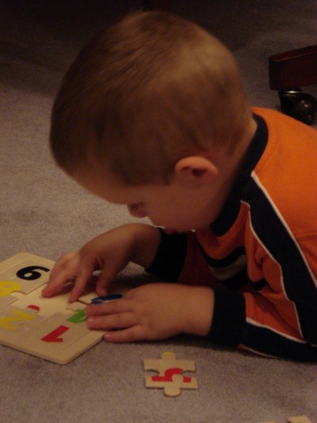 the little boy is playing with the puzzles